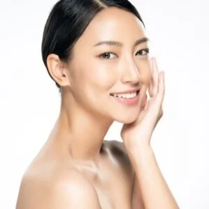 Beautiful woman with good skin, touching her face