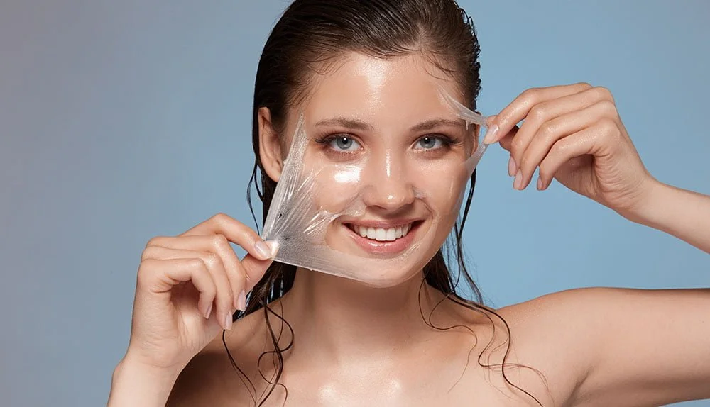 Photo of woman peeling plastic from the surface of her facial skin